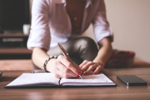 image of woman writing in journal