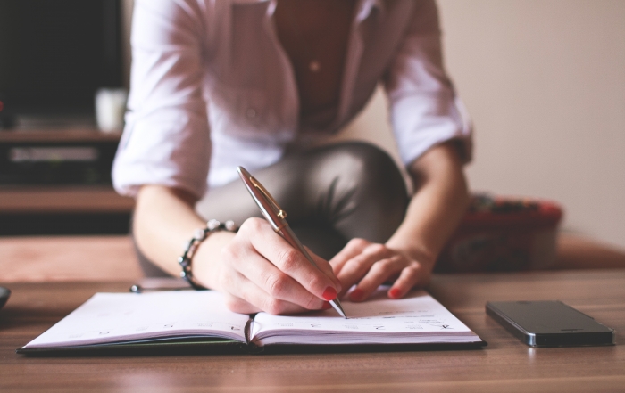 image of woman writing in journal